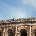 Amphithéâtre romain avec des martinets dans le ciel